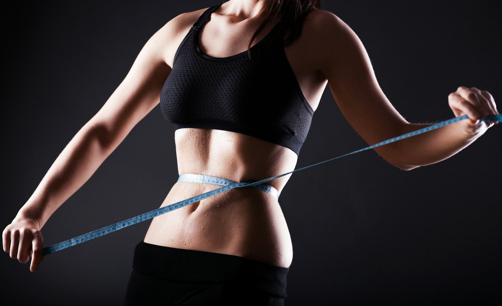 Fitness woman measuring her waist, weight loss